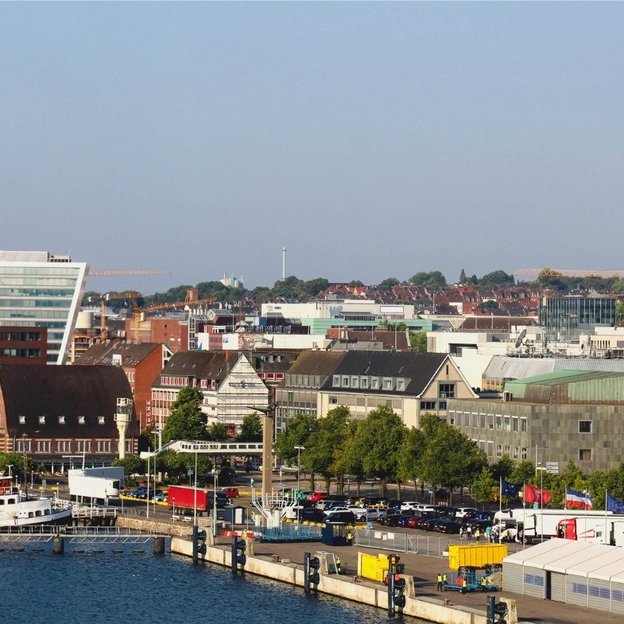 Blick auf den Kieler Hafen mit Kreuzfahrtschiff und Stadtpanorama