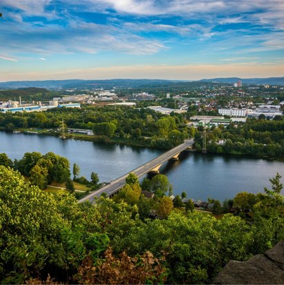 Blick auf Hagen mit Brücke über die Ruhr und grüner Landschaft im Vordergrund