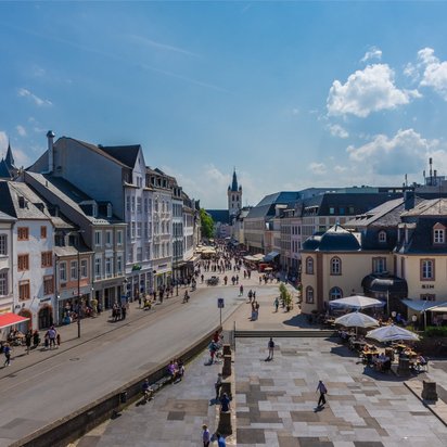 Altstadt von Trier mit Fußgängerzone, historischen Gebäuden und belebtem Platz bei Sonnenschein