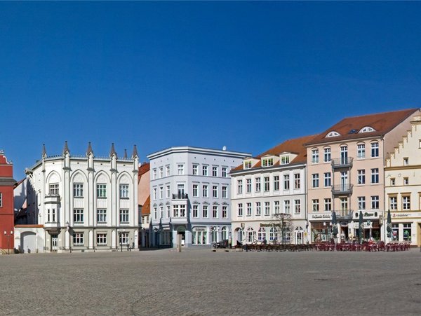 Historischer Marktplatz in Greifswald mit bunten Giebelhäusern bei blauem Himmel