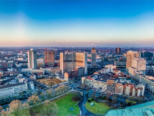 Panoramablick auf die Skyline von Essen mit Bürohochhäusern und dem Stadtpark bei Sonnenuntergang