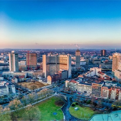 Panoramablick auf die Skyline von Essen mit Bürohochhäusern und dem Stadtpark bei Sonnenuntergang