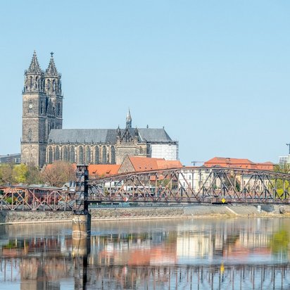 Blick auf die Stadt Magdeburg mit Dom und Elbebrücke bei klarem Himmel
