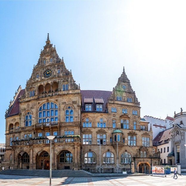 Panoramaansicht des historischen Rathauses in Bielefeld bei strahlendem Sonnenschein.
