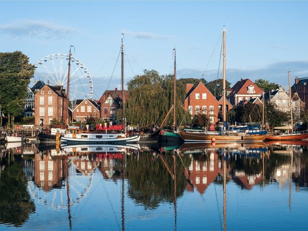 Historischer Hafen von Leer mit Segelbooten und Riesenrad im Hintergrund