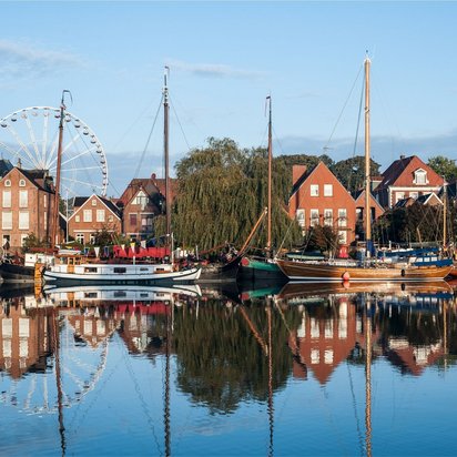 Historischer Hafen von Leer mit Segelbooten und Riesenrad im Hintergrund