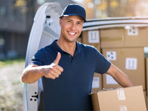 Fahrverbot vermeiden oder verkürzen Zufriedener Kurierfahrer zeigt Daumen hoch vor geöffneter Lieferwagenklappe mit Paketen