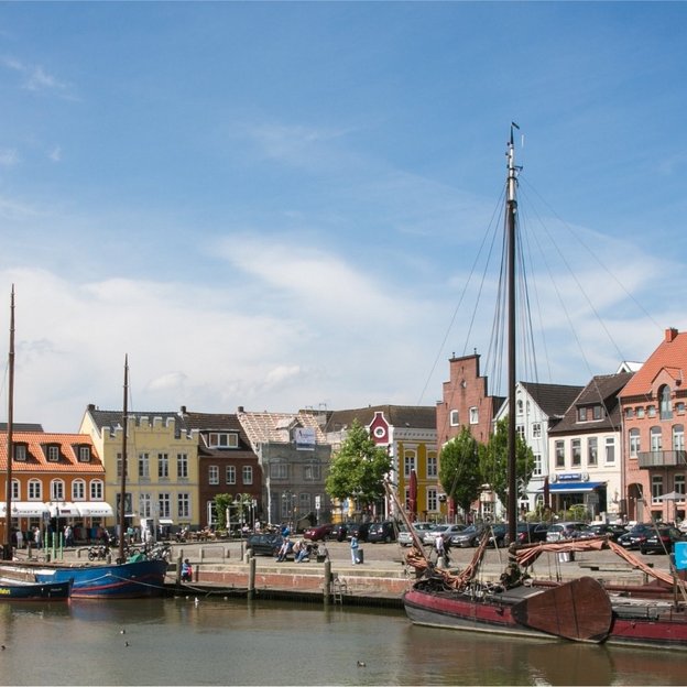 Blick auf den Hafen und die Altstadt von Husum mit Booten und bunten Häusern bei Tageslicht