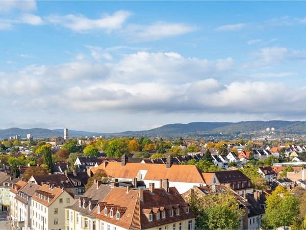 Blick über die Innenstadt von Kassel mit Hügeln im Hintergrund bei blauem Himmel
