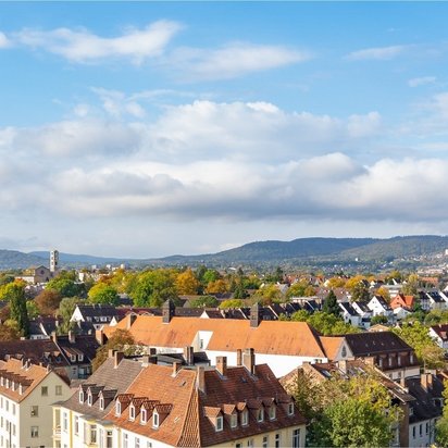 Blick über die Innenstadt von Kassel mit Hügeln im Hintergrund bei blauem Himmel